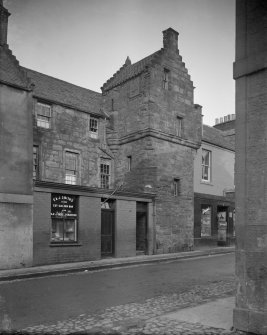 View from South West of Kellie Lodging, Pittenweem showing a window display for 'F & J Smith's famed Cut Golden Bar and Black Roll Tobaccos' and a family grocer shop