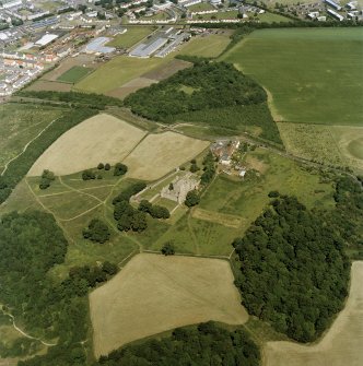Oblique aerial view centred on the remains of Craigmillar castle with the remains of the garden adjacent, taken from the SW.