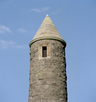 Detail of top part of tower showing window opening and and conical roof