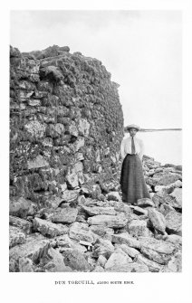 North Uist, Dun Torcuill.
View of broch wall along south edge. Women standing in view.
Photograph copied from 'North Uist' by Erskine Beveridge.