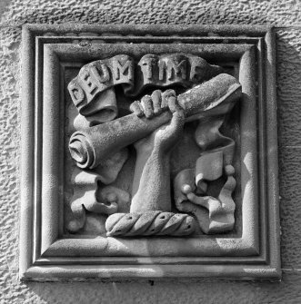 Detail of carved panel in E elevation representing hand with scroll and motto 'Deum Time' above doorway.