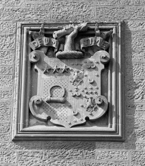 Detail of carved panel in E elevation representing coat of arms and motto 'Deum Time'.