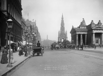 View of Princes Street, Edinburgh from west showing a busy street with horse-drawn vehicles; carts, carriages and buses.  View also includes Scott Monument and Royal Scottish Academy.  
Titled: 'PRINCES ST.  NEAR ROYAL INSTITUTION. EDINR J.P.'