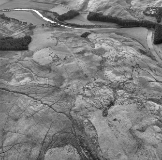 Raeburnfoot, oblique aerial view, taken from the NE, centred on the bank barrow and Raeburnfoot Roman Temporary Camp. The Reaburnfoot Roman Fort, and enclosures at Kiln Syke, are visible in the top left-hand corner of the photograph.