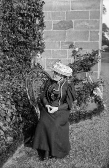 Photograph of woman sitting outside Culross Abbey House.
Scanned image from original glass plate negative. Original envelope annotated by Erskine Beveridge 'Sarah & Jacko Culross Abbey'. Possibly Erskine Beveridge's older step-sister.
