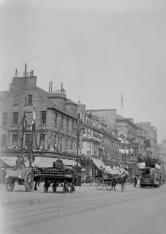 View of 134 Princes Street and eastwards from south west of the street decorated with flags and flowers for the coronation of Edward VII showing horse-drawn carts and carriages and a tram.