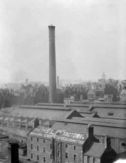 General view of Canongate, looking towards Gasworks chimney, with factory in foreground with writing on roof which reads "The "Help" Factory. Under the Management of the Distress Committee"