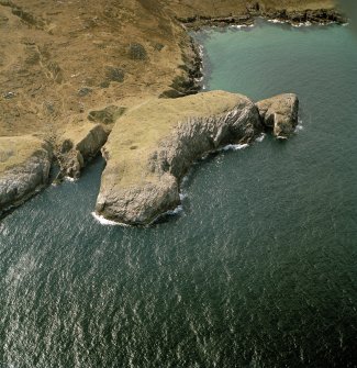 Oblique aerial view centred on the remains of Eilean Nan Caorach fort, taken from the NE.
