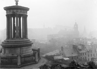 View of monument with view of Edinburgh behind, covered in fog