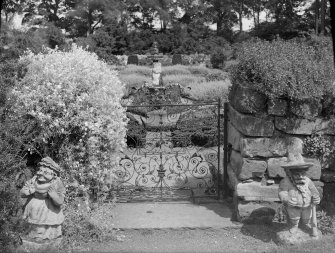 View of garden gate with figures.