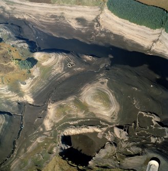 Oblique aerial view of Upper Glendevon Reservoir centred on the remains of farmsteads, enclosures and sheepfold with quarry and sheep shelter adjacent, taken during low water from the SSE.