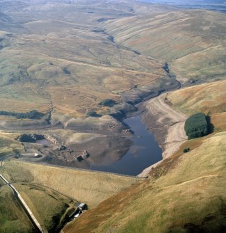 General oblique aerial view centred on the Upper Glendevon Reservoir with quarry, farmsteads, enclosures, sheepfold and possible motte adjacent, taken during low water from the E.