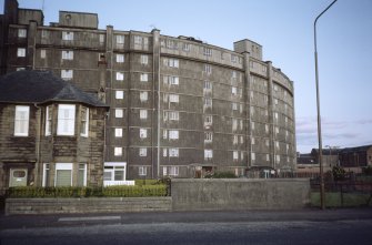 Edinburgh, Alexander Drive, Westfield Court (Westfield Flats, Gorgie): View of curved 8-storey block behind an earlier stone house.