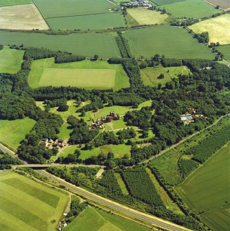 Oblique aerial view centred on the country house, with the farmsteading, the gate-lodge, the burial ground and the church adjacent, taken from the NNW.