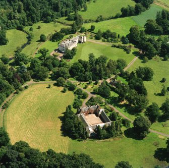 Oblique aerial view centred on the country house and stables, taken from the WNW.