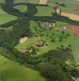 Oblique aerial view of Dunglass centred on the Collegiate Church with Dunglass House policies adjacent, taken from the E.