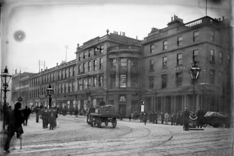 View of North Bridge at junction with Princes Street showing the Bridge Hotel on right, with horse and cart in centre of photograph. 
The buildings were demolished and this is now the site of the Balmoral Hotel.