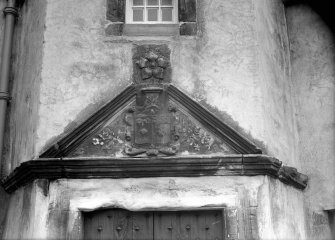 Detail of pediment with armorial panel above entrance doorway of corner tower.