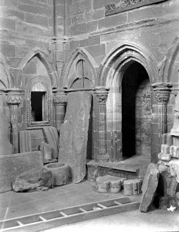 Historic photograph showing detail of tombstones and stone sculpture in sacristy.