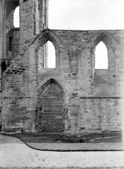 Historic photographic detail of doorway between cloister and S aisle.