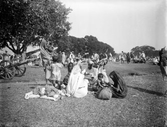 Seated family group, possibly on the Maidan, Kolkata.  The group may be pilgrims to a festival from outside Bengal.