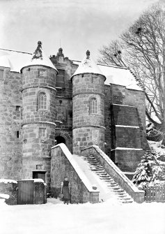 View of entrance to Rowallan Castle, Ayrshire, taken from South and showing a woman standing in the snow.