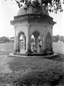 Group seated in small pavilion at edge of Manoar (Monohur) Doss's Tank, Maidan, Kolkata.  The pavilion is one of four, one at each of the corners of the tank.