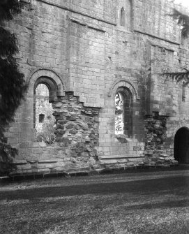 View of E wall and buttresses between windows.