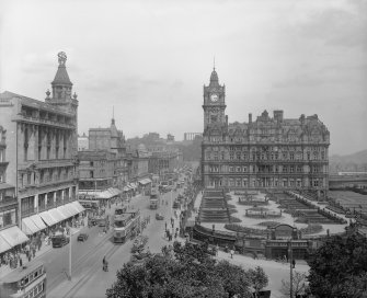 General view of Princes Street looking east towards Calton Hill showing Waverley Gardens, the North British Hotel and a busy street full of shoppers, trams, cars and horse drawn carriages.