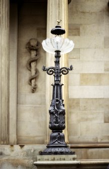 View of cast-iron lamp, one of four on wall in front of N facade.