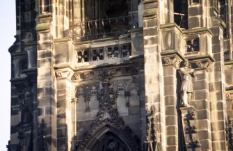 View of statue of a jester at the top of the NE flying buttress (left), and statue of a Knight Templar at the top of the NW flying buttress (right).