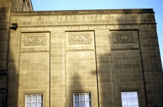 View of S wing of W facade of National Library of Scotland, showing panels carved with the 'Arts of Communication'.
