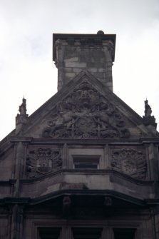 View of carved Royal Arms of Scotland and two shields on central chimney gable, E side of building (North Bridge).