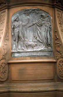 View of panel showing 'Death and Dr Hornbrook', on the back of the pedestal of the Robert Burns statue.