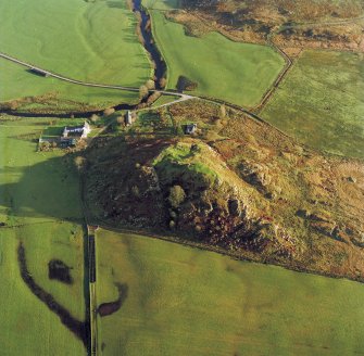 Oblique aerial view centred on the remains of Dunadd fort with the farmstead adjacent, taken from the NW.