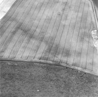 Oblique aerial view of Garvald centred on the cropmark of an enclosure, with a subcircular cropmark adjacent.  Taken from the ESE.