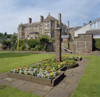 Main house, flower bed and pillar, view from South East.