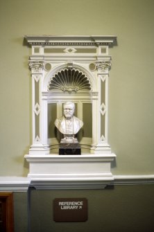 View of bust of Andrew Carnegie, in niche on staircase.