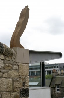View of sculpture 'Leaning Figure', on top of wall beside steps outside Dance Base.