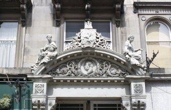 View of pediment above entrance to Albert Gallery (before restoration), showing sculptures representing Sculpture and Poetry, and a bronze portrait head of Prince Albert.