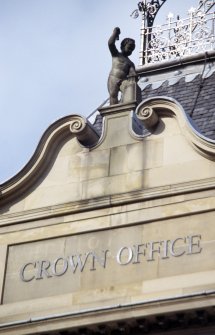 View of putto with hammer and block, at top of central pediment of Crown Office.