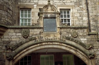 View of archway of former drill hall at 5 Forrest Hill, Edinburgh, showing shields carved with the arms of Edinburgh (left) and The Royal Scots (right), and bronze inscription panel.