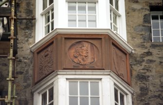 View of portrait head of Professor John Stuart Blackie, flanked by a thistle and a harp, on central oriel window of 5 North Bank Street.