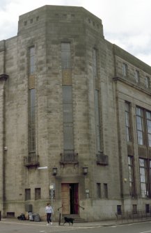 View of corner of Fountainbridge Library, showing carved relief above door and metal panels on windows.