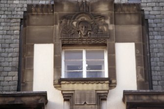 View of carved head, above third floor window.