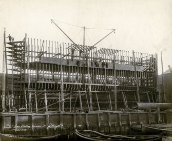 View of caisson 
Titled: 'No 2 spare floating caisson 'H' for Rosyth'.
Stamped on back: 'Sir William Arrol & Co Ltd'; 'The Clyde Shipbuilding & Engineering Co. Ld, Port Glasgow; Engineers & Boilermakers Shipbuildiers 30 Oct 1915. Repairing dock'. 


