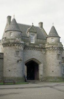 View of entrance to stables, showing carved panels on towers.