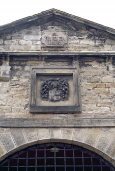 View of coat of arms of the Dick family, in gable above main entrance to stable block.