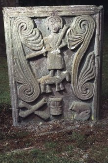 Gravestone commemorating Thomas McKeral. Portrait of Thomas on horseback, flanked by leaf-scrolls; crossbones, hourglass and skull in profile at Kirkmichael Old Parish Church.

