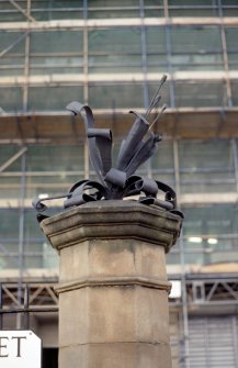 View of sculpture 'Honeysuckle', on stone pillar at end of railings on Jeffrey Street.